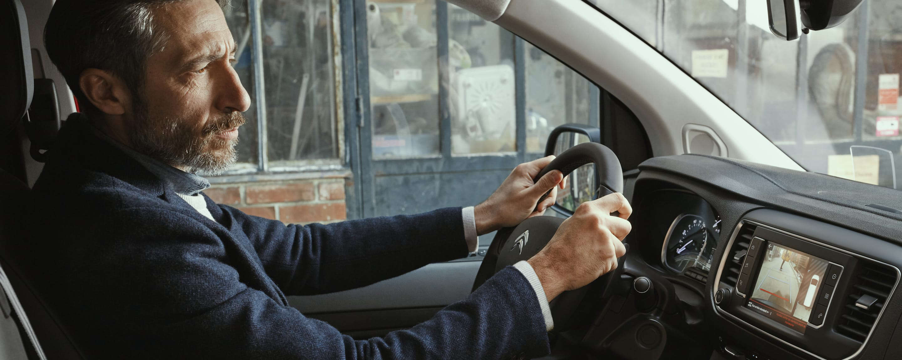 Чоловік старшого віку за кермом автомобіля CITROËN Jumpy