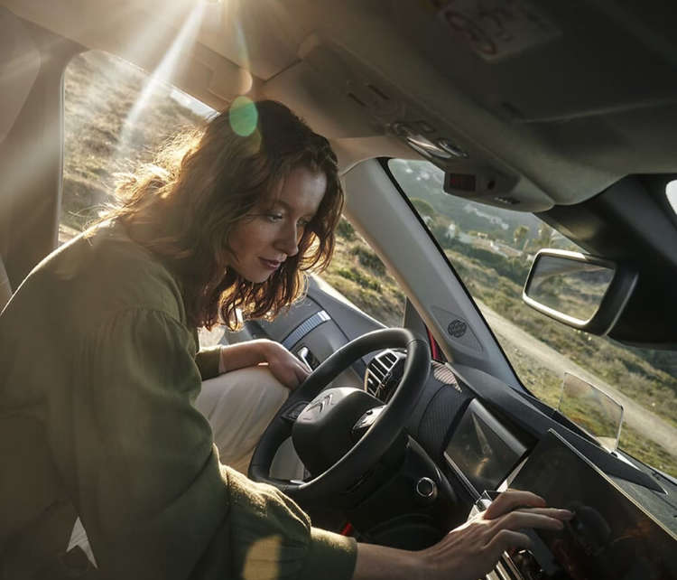 Жінка натискає на сенсорний екран у салоні автомобіля Citroën