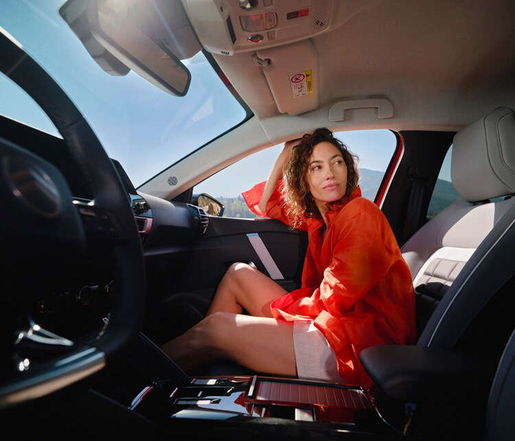 Молода жінка на передньому пасажирському сидіння у салоні Citroën C4