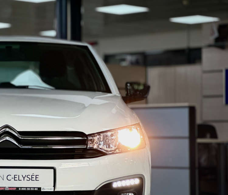 Седан Citroën C-Elysée з увімкненими фарами, вигляд спереду
